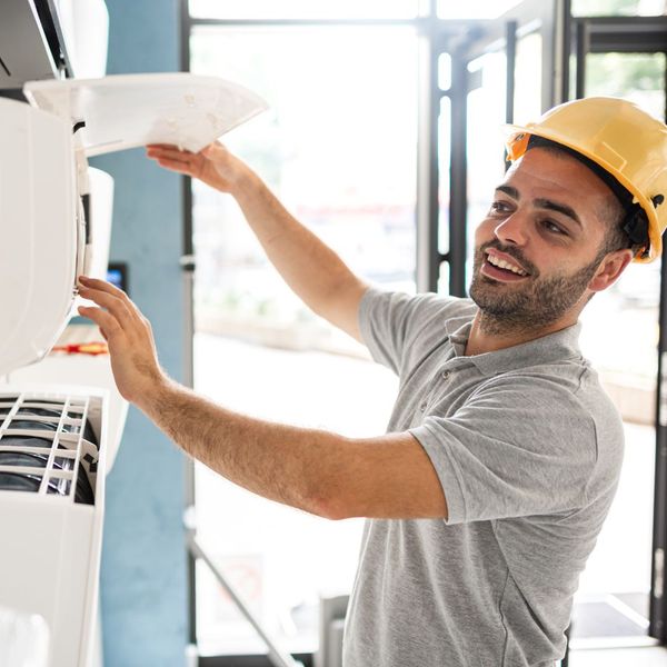 man fixing an AC machine
