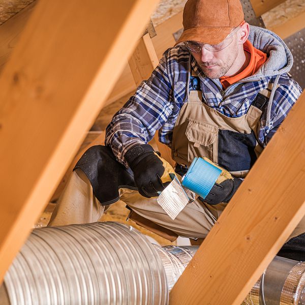 A technician working on a house's ducts