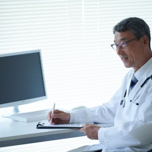 doctor taking notes at a consultation doctor taking notes at a consultation