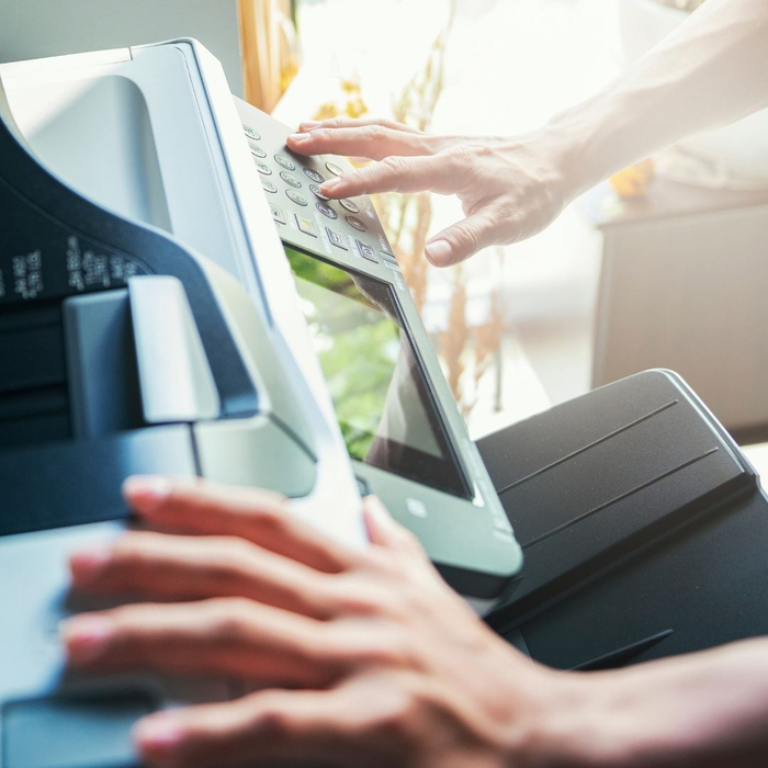 Hands operating an office printer