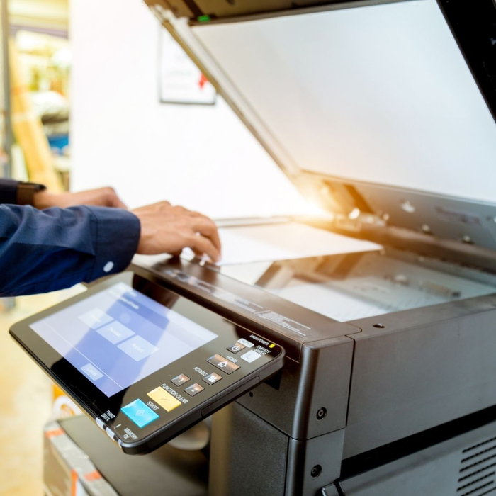 A man operates a copy machine in an office