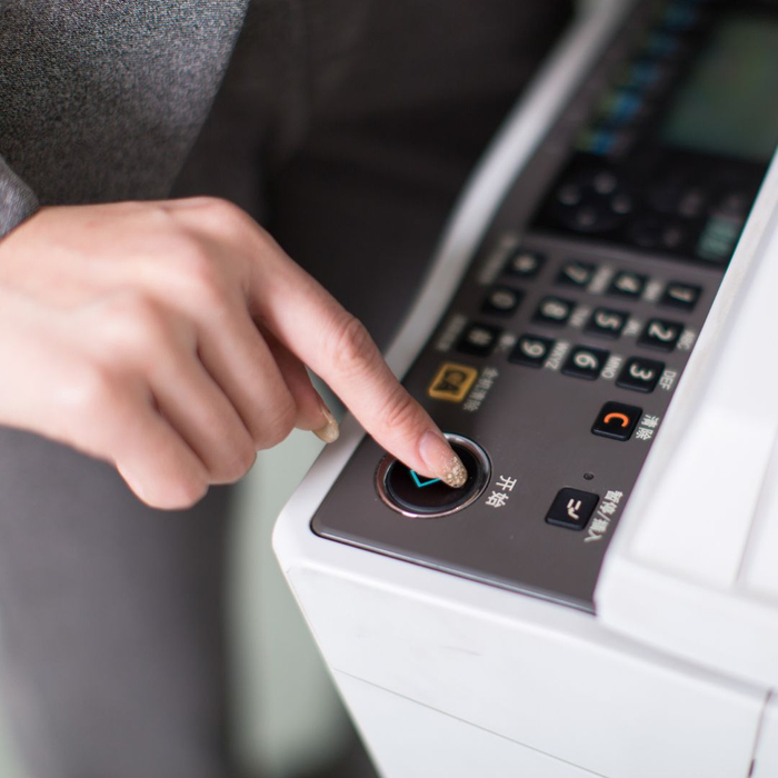 person pressing button on commercial copier