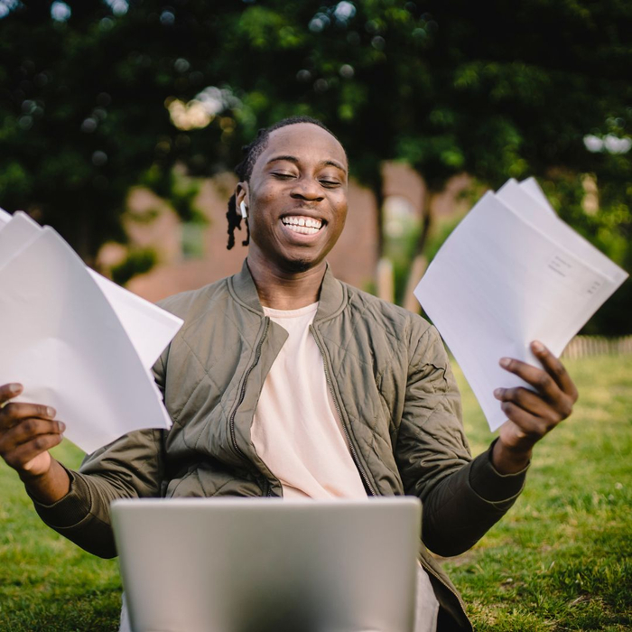 student smiling holding papers