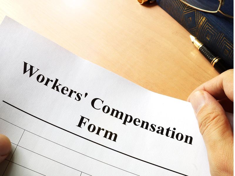 Someone holding a paper that says Workers’ Compensation Form