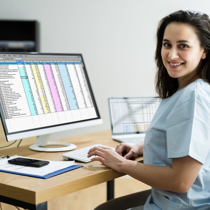 smiling nurse in front of computer