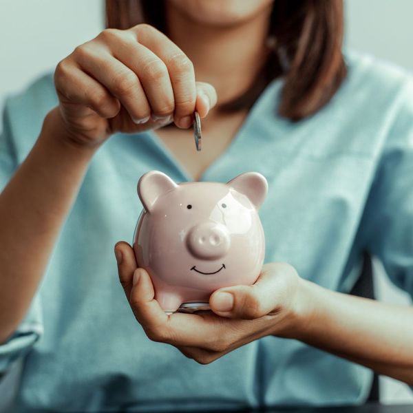 Money going into a piggybank. Money going into a piggybank.