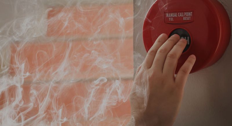 smoke and person pushing button on smoke detector