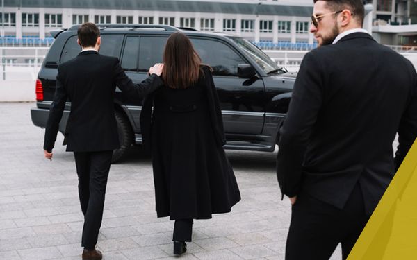woman being escorted by two men in black suits