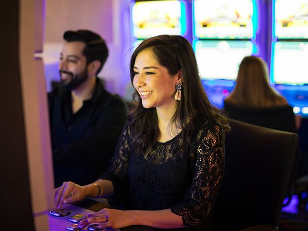 a woman having fun at a slot machine with friends