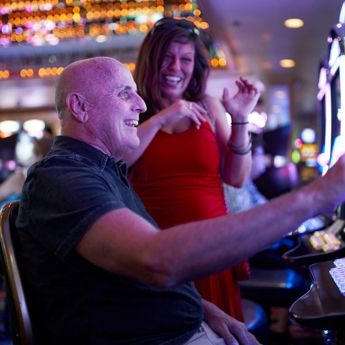A couple having fun at slot machines A couple having fun at slot machines