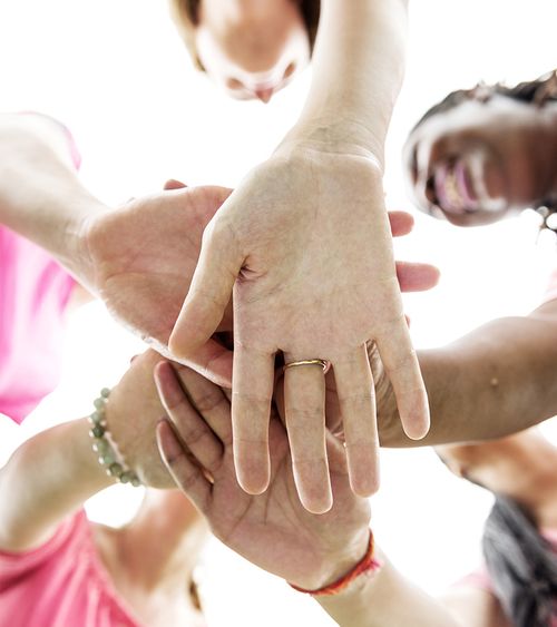 a group of diverse people with their hands together in a circle