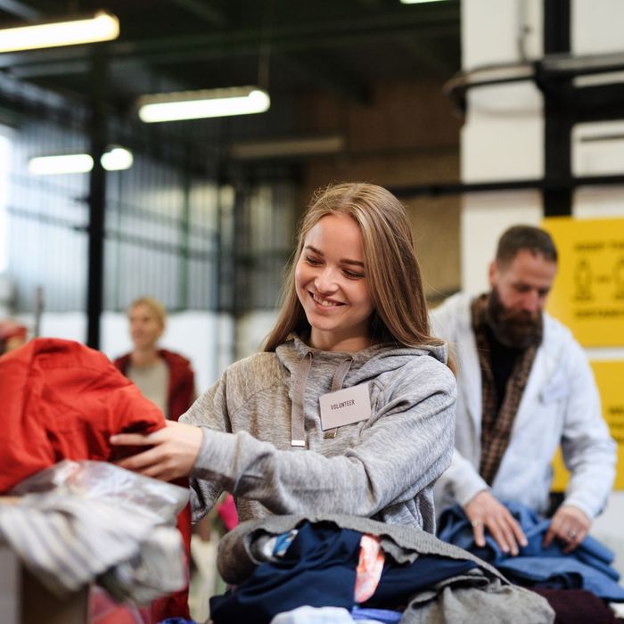A volunteer at a charity sorting clothing A volunteer at a charity sorting clothing
