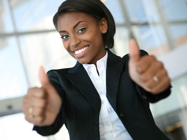 a woman in a suit giving a thumbs up