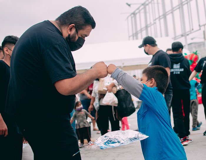 a volunteer fist bumping a child at an event