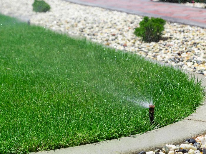  Image of a sprinkler system watering a residential lawn