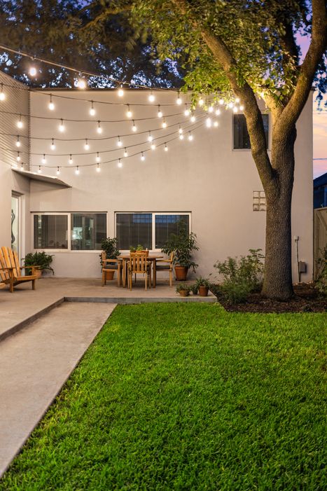 Contemporary Montrose home featuring professionally installed patio string lights by Stirling Electric & Irrigation, enhancing ambiance and outdoor usability. Modern Patio with Custom Outdoor String Lighting – Montrose, Houston