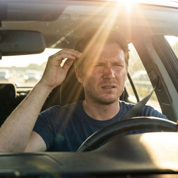 A driver with sunglare in his face.