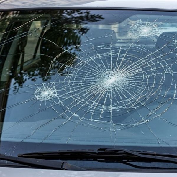 Windshield displaying multiple complex cracks and impact points.