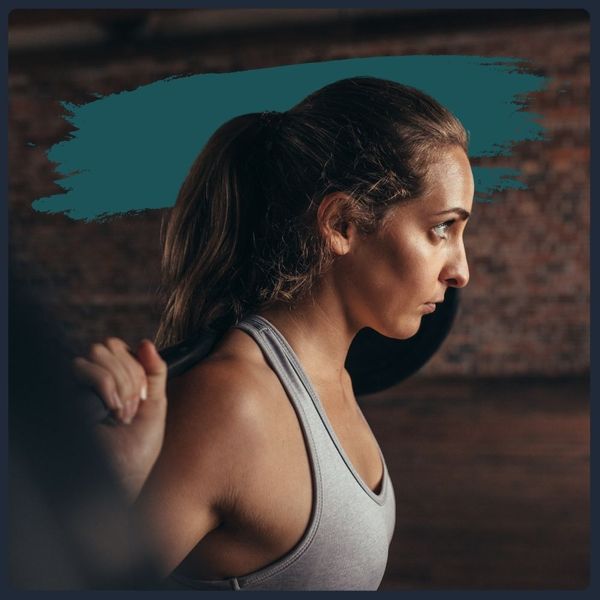 Woman with a barbell on her back, focused and ready to squat.