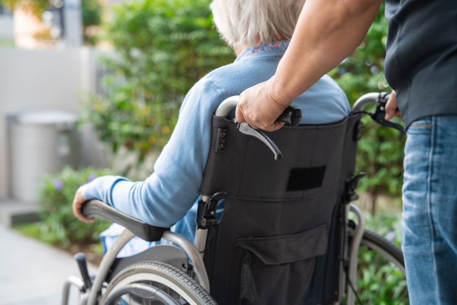 A senior being pushed in a wheelchair