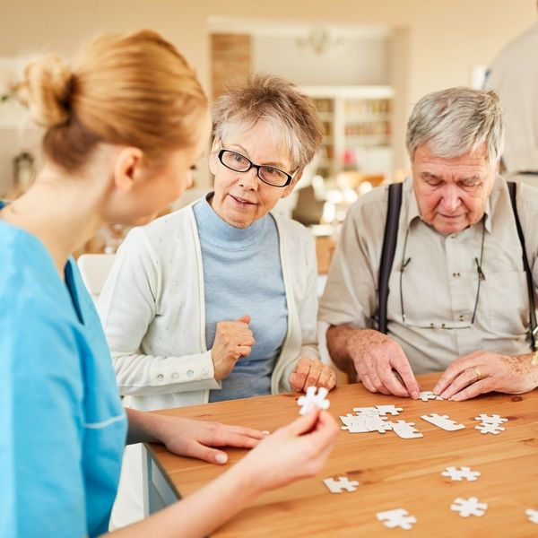 Two elderly people putting together a puzzle.