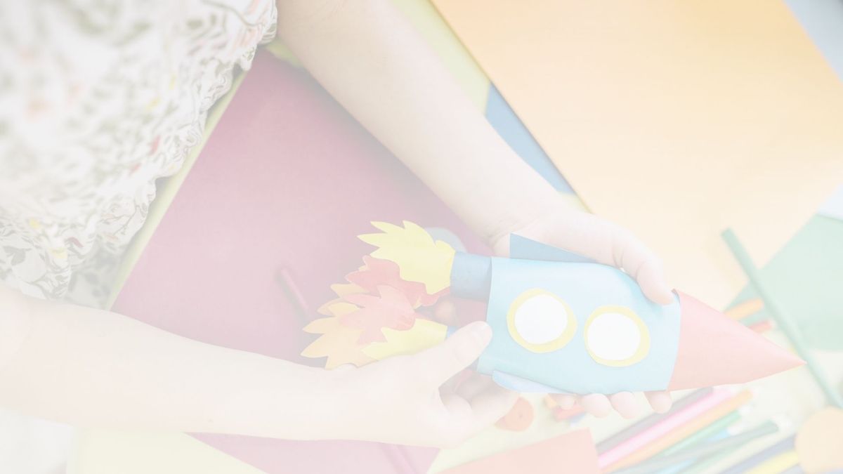 child holding a paper rocket. 