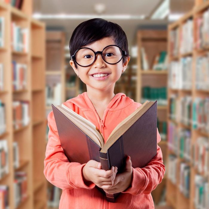 student with book in library