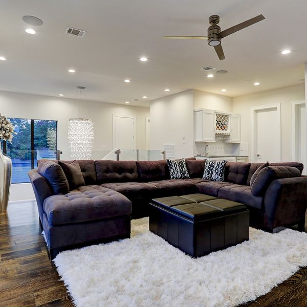Living space with a white rug and brown couch