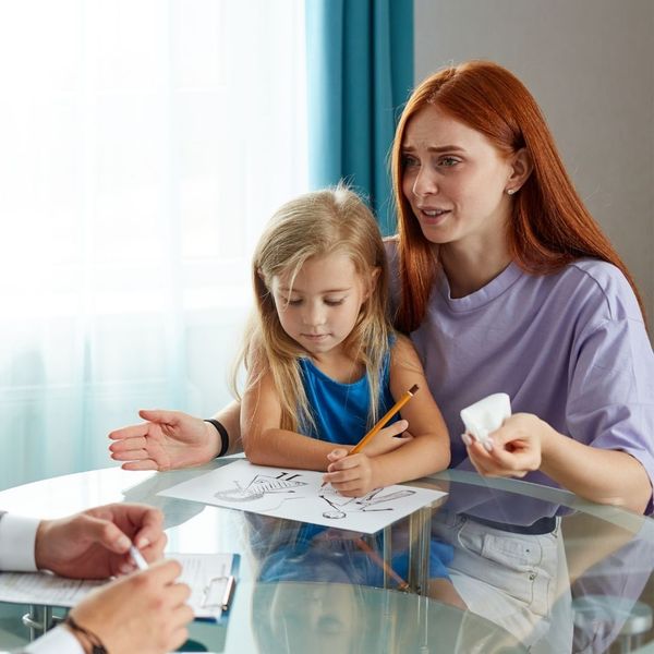 mother holding daughter while speaking with lawyer