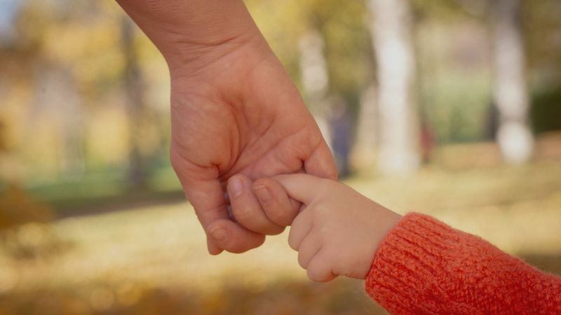 holding small child's finger holding small child's finger