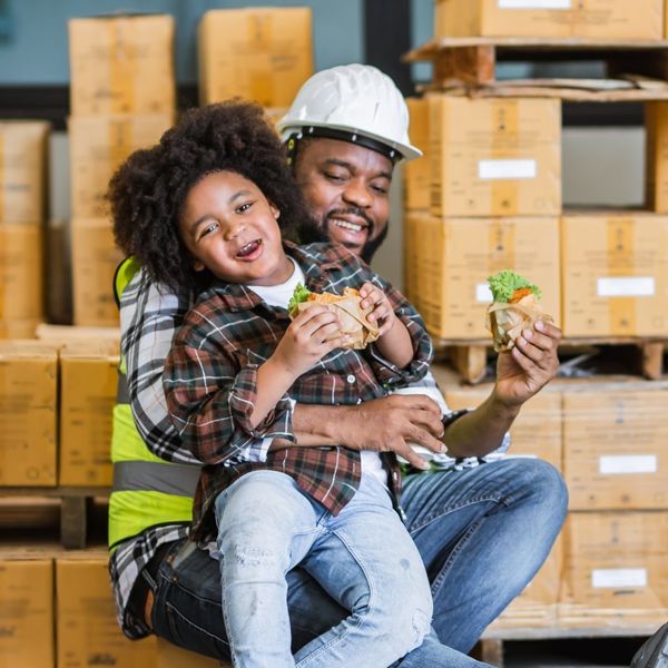 father eating lunch with son at work