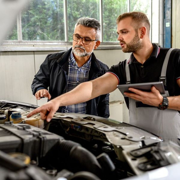 Auto technician assessing car 