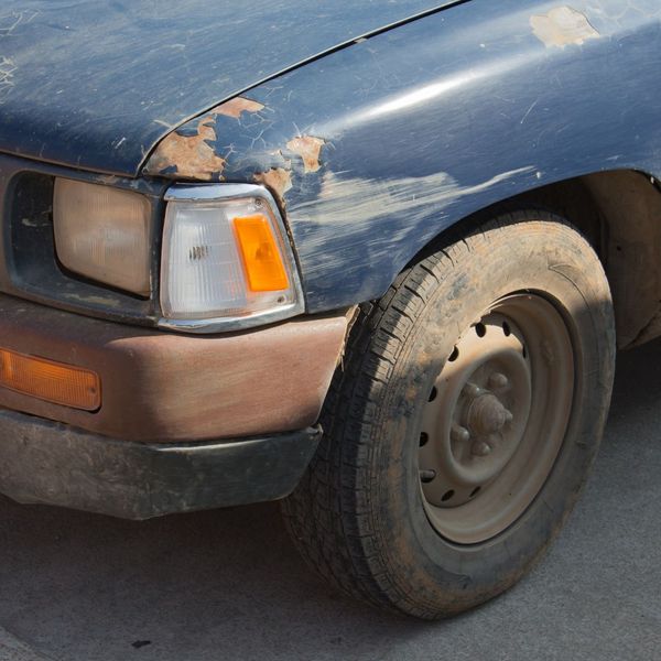 blue car with a little rust above the headlight