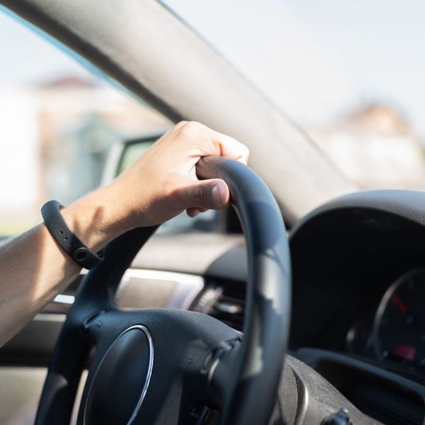 Person with their hand on the steering wheel