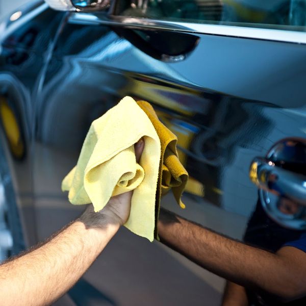 Person using a rag to polish a car. 