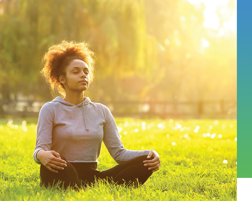 woman meditating in grass