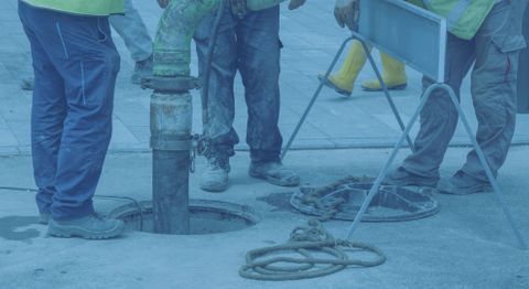 plumbers working on pipes outside