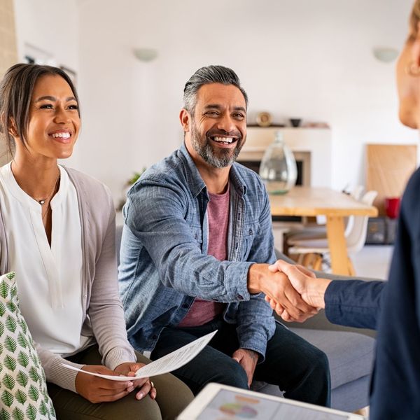 couple shaking hands with insurance agent