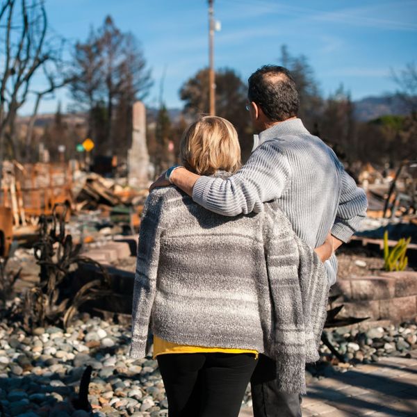 couple outside of burnt down house