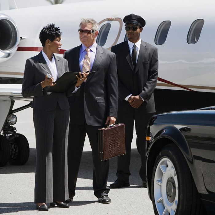 A chauffeur standing by a his clients on a runway