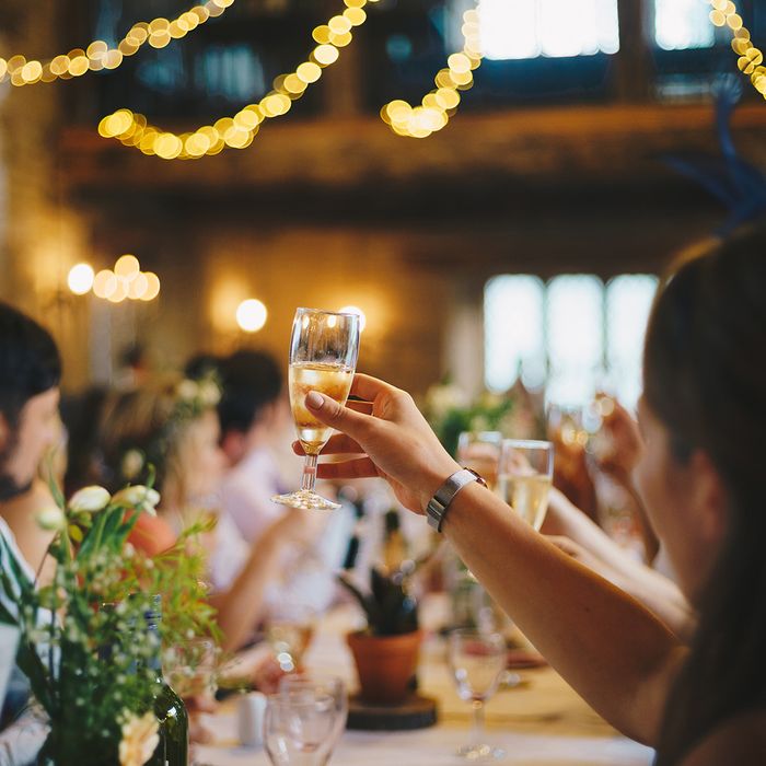 Guests raising their glasses in a toast during a wedding reception