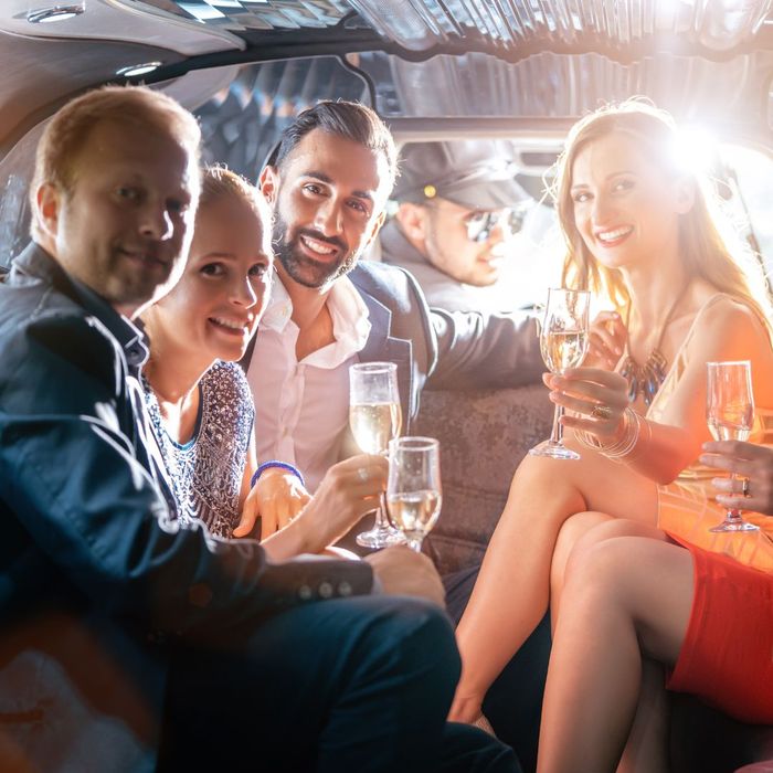 A group of people with champagne in a private vehicle