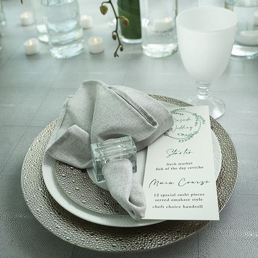 Plates and glassware at a wedding guest's spot at a table