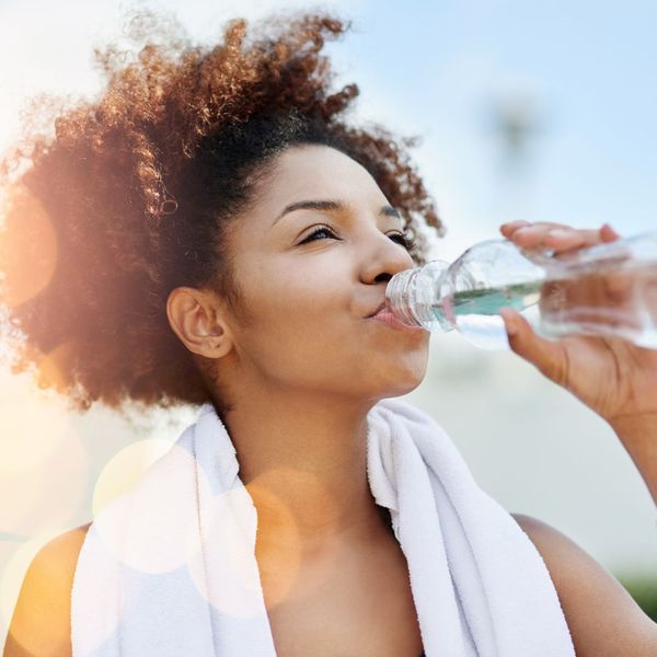 happy woman drinking water after workout