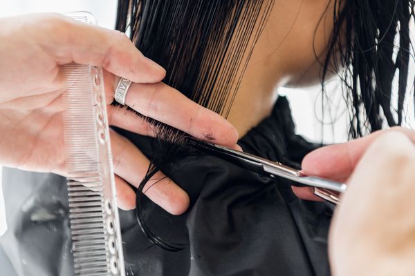 mans-hands-cut-and-comb-female-dark-brown-hair-in--D7AR95K.jpg