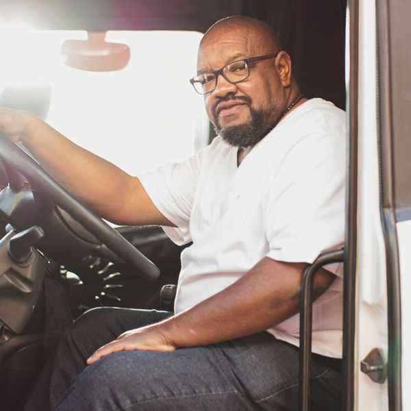 man in drivers seat of semi truck