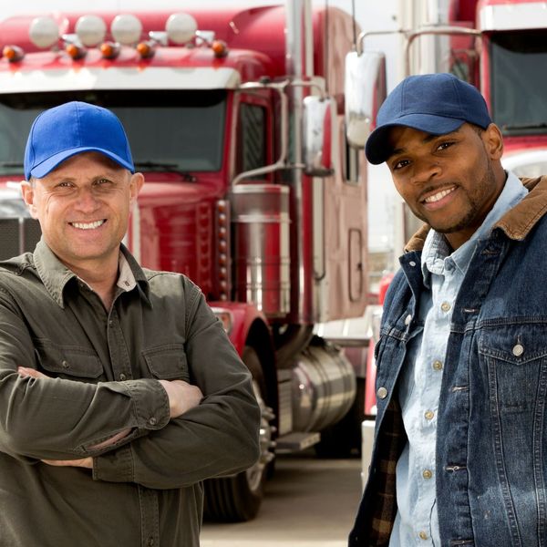 2 truck drivers smiling at camera