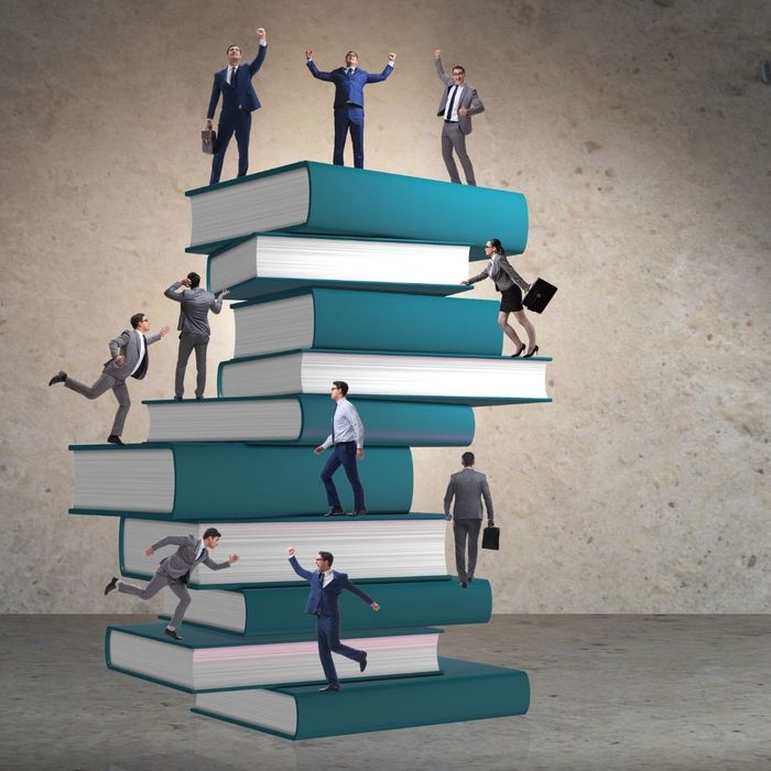employees climbing a stack of books