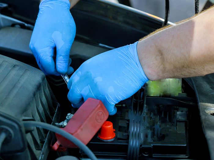 Mechanic replacing a car battery.