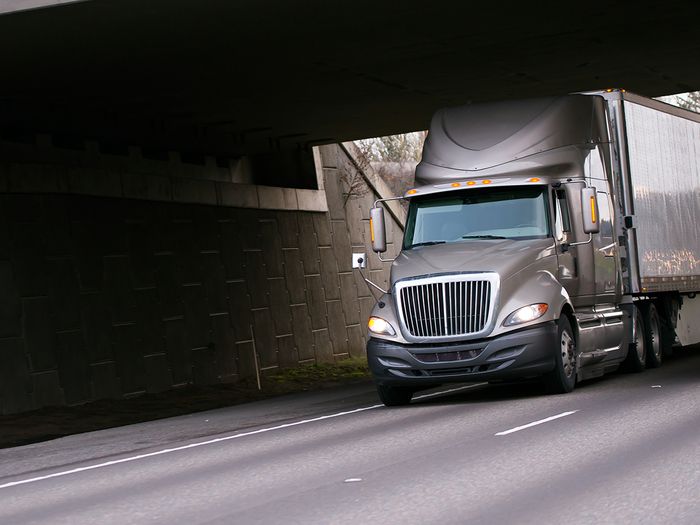 A modern semi-truck driving on an open highway.